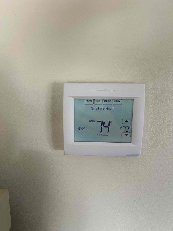 Completed annual Care Plan tune-up on Daikin heat pump system (Model ASZ150361RAA) with air handler located in laundry room. Performed comprehensive maintenance inspection, verified system operation with Honeywell thermostat reading 74°F indoor temperature in heating mode, and noted customer-provided Aprilaire media filter in place.