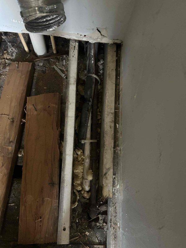Responded to service call for kitchen remodeling project where removal of island platform exposed existing HVAC ductwork beneath floor. Upon arrival, inspected exposed floor cavity and identified flexible metallic supply duct running between floor joists along with PVC drain lines. Assessed ductwork condition and routing to determine if system was active and functional. Documented existing duct configuration with photographs showing duct suspended by straps in crawlspace area with accumulated debris present. Consulted with installer regarding original equipment layout and provided recommendations to customer on options for either removing non-functional ductwork or rerouting active supply lines to accommodate kitchen renovation plans.