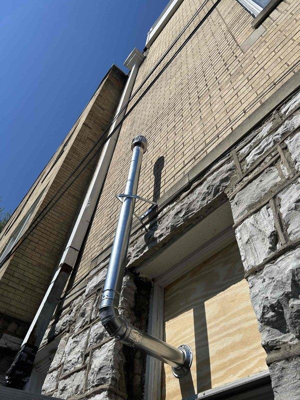 Installed new 3" flue pipe for water heater, routing it through kitchen door window and up the exterior building wall to a flue cap to ensure proper carbon monoxide ventilation. Sealed and covered the window opening to eliminate gaps and cracks, then verified proper ventilation and confirmed no leaks in the flue system. Behind the ice maker, installed a new condensation pump and rerouted the ice maker drain line into the pump, with discharge line running to the 3-compartment sink just above the ice maker location. Tied into the existing 1" gas line in the kitchen and ran approximately 6 feet of new 1/2" gas line to the relocated gas stove position. Installed a shutoff valve on the new gas line and left it capped for future appliance hookup. Completed pressure testing on all gas connections and verified no leaks on any services performed.