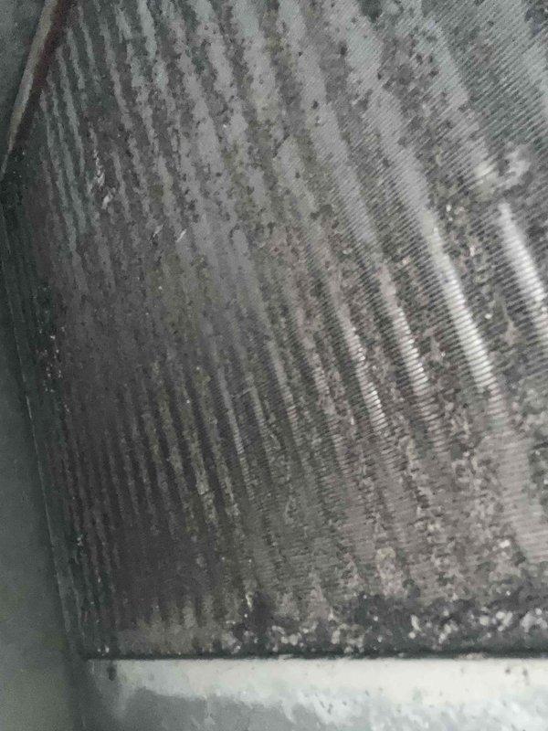 Completed comprehensive Care Plan maintenance on dual HVAC system consisting of two heat pumps, two air handlers, one humidifier, and washable filter. Performed thorough inspection and tune-up procedures on all components per maintenance protocol.

Inspected evaporator coils on both air handler units, documenting condition with photographic evidence. Coils showed moderate to heavy accumulation of dust, dirt, and debris between fins, with visible discoloration and biological growth in several areas. Noted uneven contamination patterns across coil surfaces, particularly concentrated in middle sections where airflow patterns typically deposit particles. Metal fins displayed grayish-green tinting with darker spots indicating extended operational period since last cleaning.

Assessed heat exchanger fins on both systems, finding similar accumulation of grime and oxidation on aluminum surfaces. Documented dirt buildup lodged between fin spaces that could restrict airflow and reduce heat trans