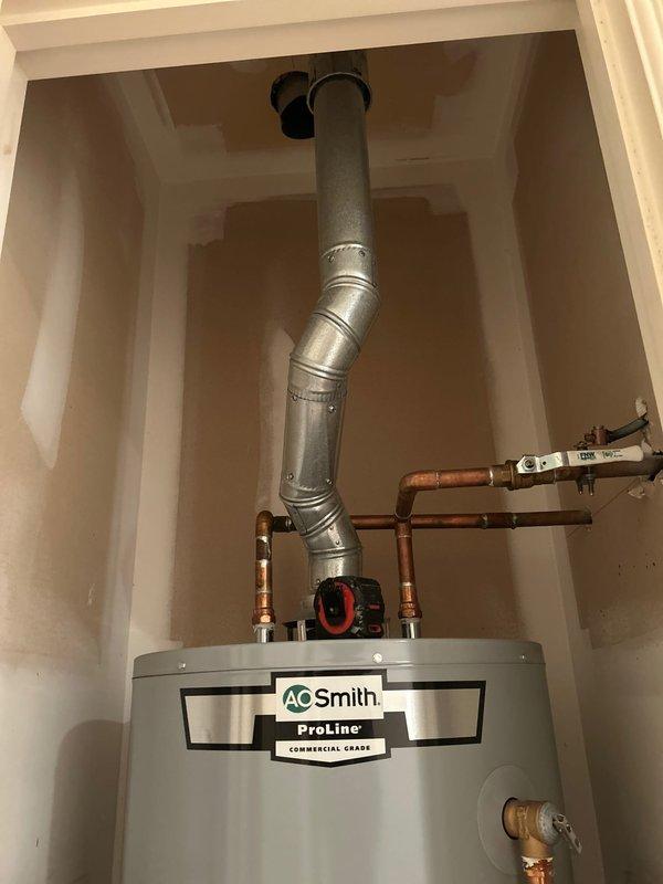 Responded to service call for assessment of water heater venting system flagged by inspector as undersized for the installed unit. Upon arrival, inspected A.O. Smith ProLine Commercial Grade tanked water heater located in second-floor utility closet, approximately one year old and in otherwise good operating condition.

Conducted thorough evaluation of existing venting configuration, including measurement and documentation of current vent pipe diameter and routing. Utilized digital level to verify proper pitch and alignment of exhaust vent system. Examined the galvanized metal flue pipe extending from top of unit, including elbow joint and connection points secured with metal bands. Assessed clearances, combustion air supply, and overall installation compliance with manufacturer specifications and current building codes.

Confirmed inspector's findings that existing vent pipe diameter does not meet required specifications for this commercial-grade water heater model. Documented install