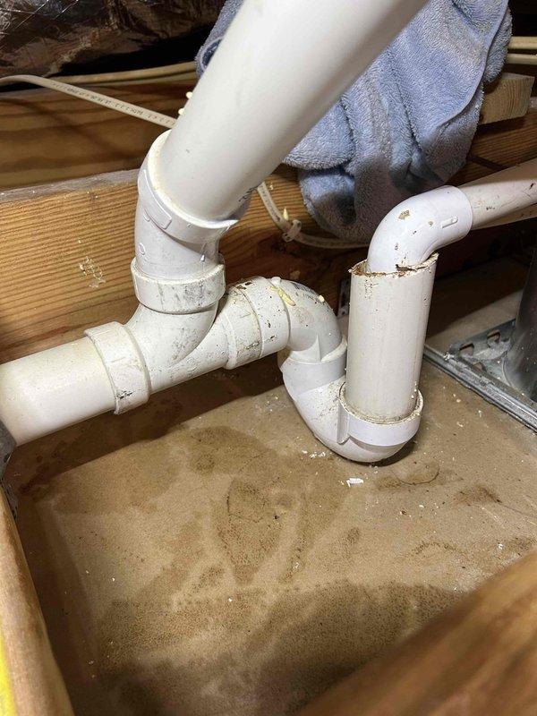 Responded to water leak complaint with indoor unit located in attic space. Upon inspection, identified active condensate drainage issue causing water to drip through ceiling fixture below. Examined PVC condensate drain line configuration and P-trap assembly in attic, finding debris accumulation and improper drainage flow. Cleared blockage from drain line, verified proper trap operation, and confirmed condensate flow restoration. Tested system operation and verified no further leakage present.