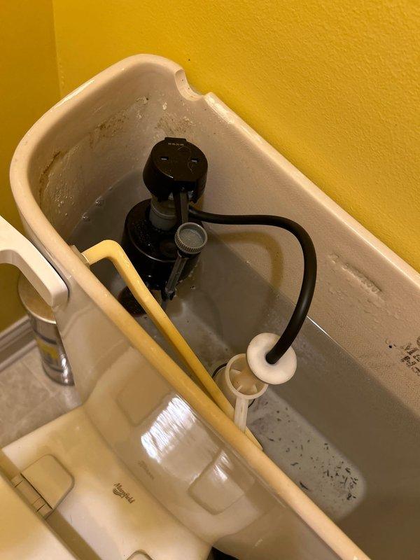 Responded to service call for guest bathroom toilet running constantly. Upon inspection, identified faulty flush valve and fill valve components with visible mineral buildup affecting proper operation. Removed tank lid and assessed internal mechanisms, noting deteriorated flapper seal and compromised fill valve causing continuous water flow. Recommended replacement of flush valve assembly and fill valve to restore proper function and prevent water waste.