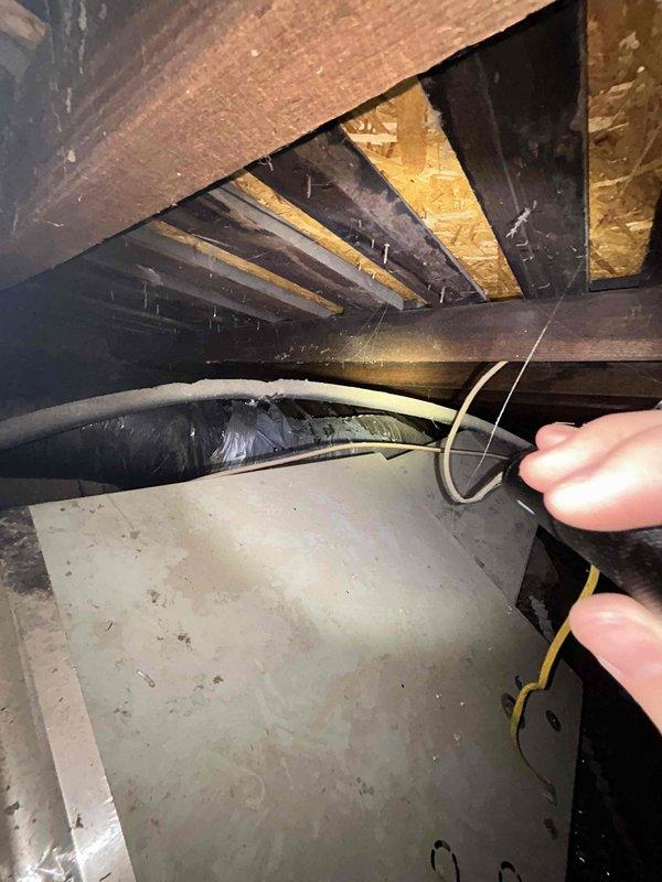 Responded to no cooling complaint on 15-year-old electric upstairs HVAC system where outdoor fan had not been operating for approximately two weeks. Upon arrival, accessed attic-mounted air handler and performed diagnostic testing on electrical components and control systems. Conducted visual inspection of ductwork, noting accumulated dust and age-related wear on flexible ducting, and assessed overall system condition in attic space. Performed electrical measurements and tested fan motor operation to identify failure point causing loss of cooling capacity.