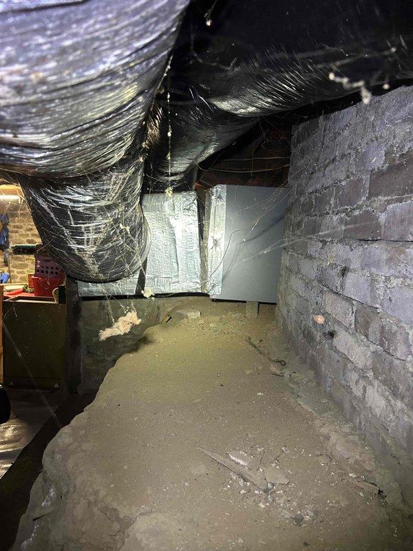 # HVAC Service Call - No Cooling Condition

Responded to service call for air conditioning system with no cooling and inoperative fan. Upon arrival, conducted initial assessment to determine system age and operational status.

## Diagnostic Procedures

Performed visual inspection of indoor air handler unit located in crawl space. Accessed system through confined crawl space entry, navigating dirt floor and concrete block foundation walls. Located air handler and associated ductwork with reflective insulation wrapping.

Inspected air filtration system and found 20x24x1 Carbotron filter installed in system. Evaluated filter condition and surrounding ductwork for dust accumulation and airflow restrictions. Noted dust buildup on metal surfaces and duct seams indicating potential maintenance concerns.

Examined electrical components and fan motor assembly for operational failures. Checked for proper power supply to unit and verified control circuit functionality. Assessed blower motor condi