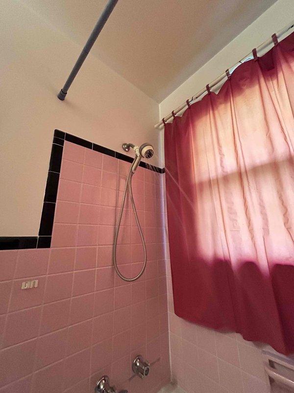 Responded to service call for slow-draining bathroom sink and hissing toilet tank in early 1970s home where issues had persisted for approximately one month. Inspected bathroom plumbing fixtures and identified partial blockage in sink drain causing delayed drainage. Cleared obstruction from sink drain line using appropriate drain cleaning equipment, restoring proper water flow. Examined toilet tank components and located source of hissing sound, which was determined to be a faulty fill valve allowing continuous water seepage. Replaced defective fill valve assembly with new unit to eliminate air leak noise and prevent water waste. Tested both fixtures after repairs to verify proper operation—sink now drains at normal rate and toilet tank fills quietly without hissing. Documented conditions with photographs showing vintage pink tile bathroom with chrome fixtures and sink drainage test confirming restored functionality.