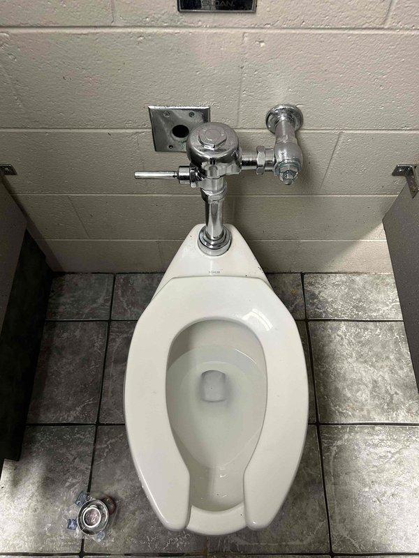 Responded to commercial restroom for toilet that would not flush correctly. Upon inspection, diagnosed faulty automatic flush valve system on wall-mounted Sloan flush valve assembly. Replaced defective auto flush device with new unit, tested manual flush handle operation, and verified proper water flow and complete flush cycle. Toilet now functioning properly with restored automatic and manual flush capabilities.