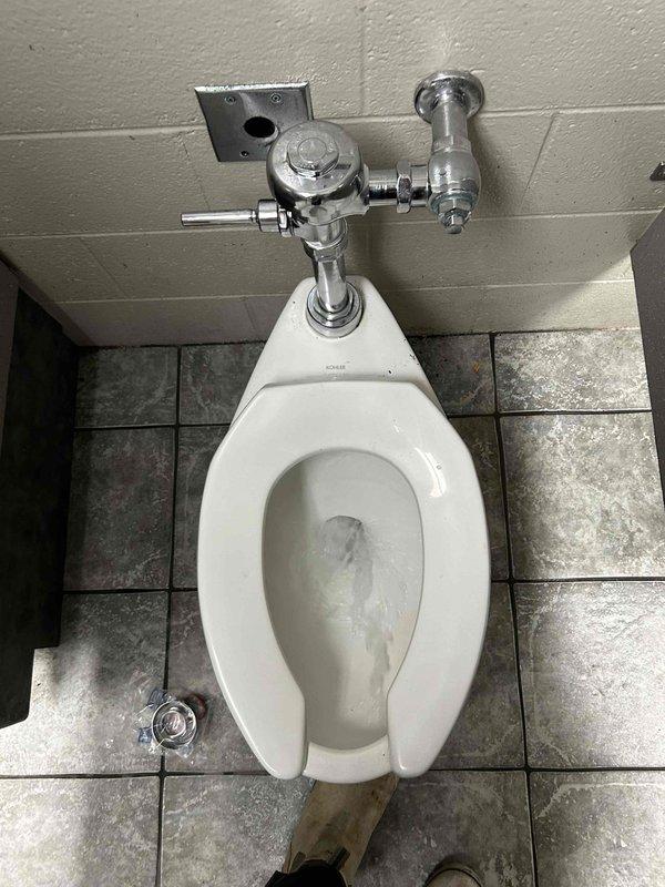 Responded to commercial restroom for toilet that would not flush correctly. Upon inspection, diagnosed faulty automatic flush valve system on wall-mounted Sloan flush valve assembly. Replaced defective auto flush device with new unit, tested manual flush handle operation, and verified proper water flow and complete flush cycle. Toilet now functioning properly with restored automatic and manual flush capabilities.