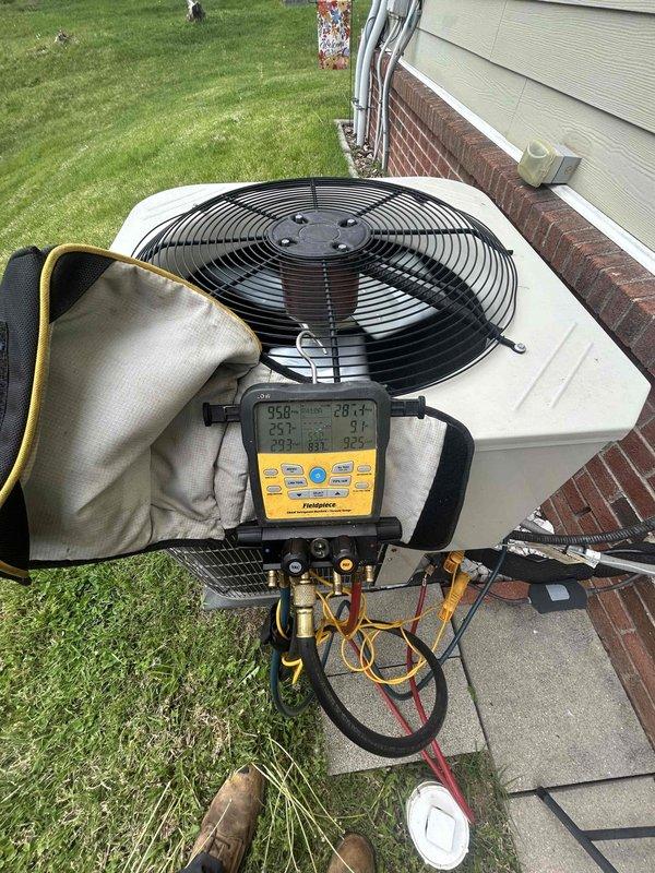 Performed routine monthly club maintenance on residential heat pump system with air handler located above garage. Conducted comprehensive spring/summer inspection including refrigerant pressure and temperature diagnostics using digital manifold gauges on outdoor condensing unit. Connected testing equipment to service ports to verify proper system operation, refrigerant charge levels, and overall unit performance. Inspected condenser unit positioned on concrete pad adjacent to building, checking electrical connections, refrigerant lines, and mechanical components for proper function and wear. System operating within normal parameters with no deficiencies noted during this scheduled preventive maintenance visit.