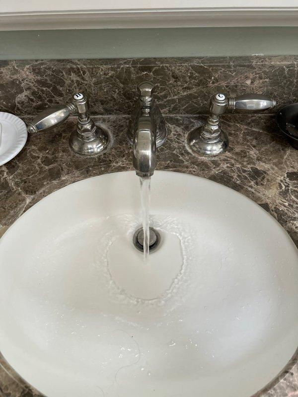 Responded to service call for toilet flushing issues and performed comprehensive plumbing assessment. Diagnosed and addressed toilet flush mechanism malfunction to restore proper operation. Inspected master bathroom plumbing fixtures and identified corroded shut-off valve beneath sink with visible green oxidation at connection point, requiring replacement for leak prevention. Evaluated faucet aerator flow performance and provided replacement recommendation. Verified sink supply lines and drain assembly condition. Conducted visual inspection of water heater unit to assess age, condition, and remaining service life for replacement planning purposes. Documented plumbing infrastructure with photographs showing under-sink corrosion and fixture conditions to support estimate preparation for recommended valve and aerator replacements.
