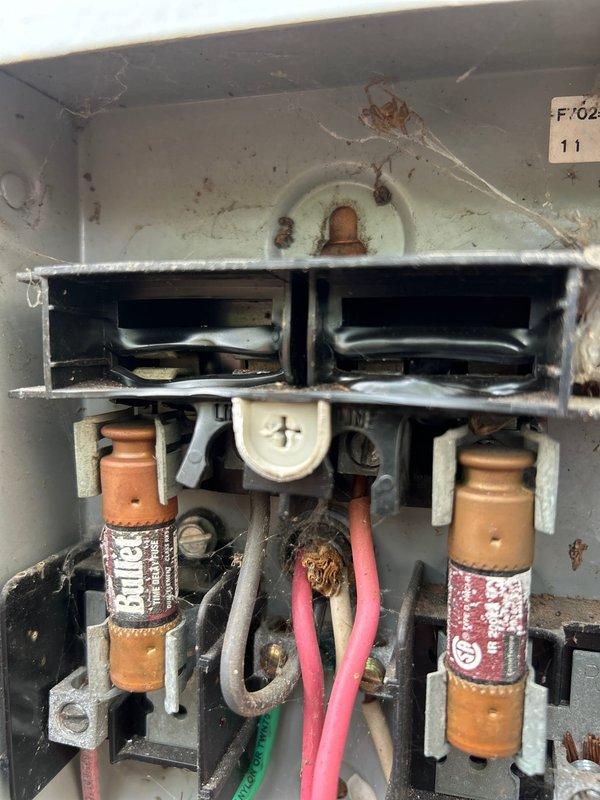 Responded to service call back for dual AC system with gas furnace in attic and basement. Previous technician reported no issues, but unit subsequently failed to cool. Performed comprehensive maintenance tune-up (MTU) that was not properly completed during last visit. Thoroughly cleaned outdoor condenser units that had been neglected. Inspected and documented condition of electrical disconnects, noting significant dirt accumulation, corrosion on fuse holders, and degraded wiring connections. Evaluated Armaflex insulation on refrigerant lines for potential replacement needs. Removed 3-year-old UV bulb from upstairs air scrubber unit for replacement and provided pricing for new bulb. Photographed electrical panel conditions showing tarnished copper fuses, corroded terminals, and excessive debris buildup requiring attention. Addressed cooling failure by identifying maintenance deficiencies and equipment conditions that contributed to system shutdown.