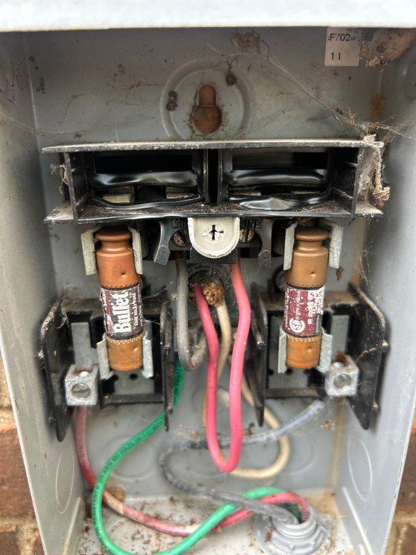 Responded to service call back for dual AC system with gas furnace in attic and basement. Previous technician reported no issues, but unit subsequently failed to cool. Performed comprehensive maintenance tune-up (MTU) that was not properly completed during last visit. Thoroughly cleaned outdoor condenser units that had been neglected. Inspected and documented condition of electrical disconnects, noting significant dirt accumulation, corrosion on fuse holders, and degraded wiring connections. Evaluated Armaflex insulation on refrigerant lines for potential replacement needs. Removed 3-year-old UV bulb from upstairs air scrubber unit for replacement and provided pricing for new bulb. Photographed electrical panel conditions showing tarnished copper fuses, corroded terminals, and excessive debris buildup requiring attention. Addressed cooling failure by identifying maintenance deficiencies and equipment conditions that contributed to system shutdown.