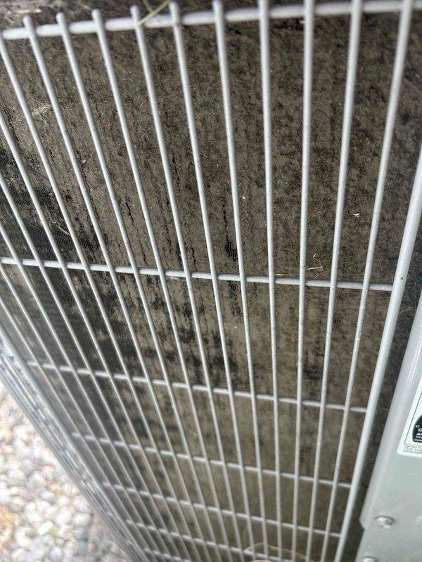 Responded to no-cool complaint on 14-year-old electric air conditioning system that was reportedly unable to maintain temperature setpoint. Previous contractor had diagnosed failed compressor and recommended full system replacement. Upon arrival, performed visual inspection of outdoor condensing unit and discovered severely restricted condenser coil with heavy accumulation of dirt, dust, and debris completely blocking airflow through fins. Coil contamination was preventing adequate heat rejection, causing system to run continuously without achieving desired cooling. Documented condition with photographs showing extent of buildup behind protective grille. Recommended thorough condenser coil cleaning to restore proper airflow and system operation before pursuing compressor replacement, as restricted airflow can mimic compressor failure symptoms.