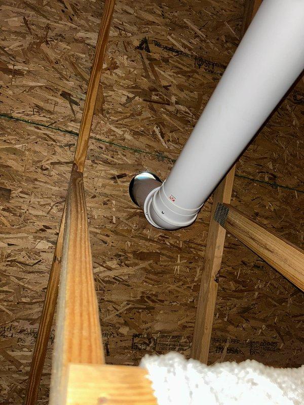Responded to service call for Rinnai tankless water heater experiencing error codes 10, 11, and 49, with improper venting identified by roofing contractor. Upon inspection, confirmed venting system was incorrectly installed with improper pitch and inadequate penetration sealing through roof structure, causing condensate backup and triggering flame failure and ignition codes. PVC vent pipe showed incorrect angle through attic space without proper support or drainage slope, allowing condensate accumulation that resulted in visible water damage to flooring beneath unit. Diagnosed that improper venting configuration prevented adequate exhaust flow and caused unit malfunctions. Verified active manufacturer warranty coverage on unit itself, though labor charges apply for venting corrections. Provided detailed assessment of required venting repairs including proper vent pipe repositioning, correct pitch installation per manufacturer specifications, professional roof penetration sealing, and c
