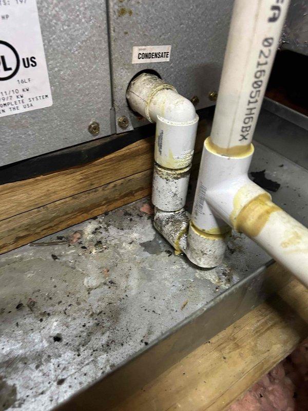 Responded to service call for non-operational 15-year-old geothermal air conditioning system with reported blower fan failure. Coordinated gate access call prior to arrival for evening appointment window. Upon inspection, accessed attic-mounted air handler unit and assessed system components including condensate drainage lines and refrigerant piping connections. Documented existing equipment condition showing age-appropriate wear, moisture accumulation on insulated refrigerant lines, and water staining around condensate connections indicating previous drainage activity. Photographed air handler installation, ductwork connections, electrical wiring, and PVC condensate drain routing for service records. Evaluated blower motor operation, electrical supply to unit, and overall system functionality to diagnose reported cooling failure and determine necessary repairs for geothermal heat pump system.