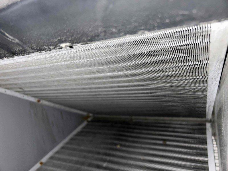 Responded to no cooling complaint on 11-year-old AC/furnace system blowing room temperature air. Upon inspection, found evaporator coil heavily contaminated with dust and debris accumulation, restricting airflow and preventing proper heat exchange. Performed diagnostic measurements and documented coil condition with severely clogged fins throughout the heat exchanger surface, consistent with extended operation without maintenance on aging equipment.