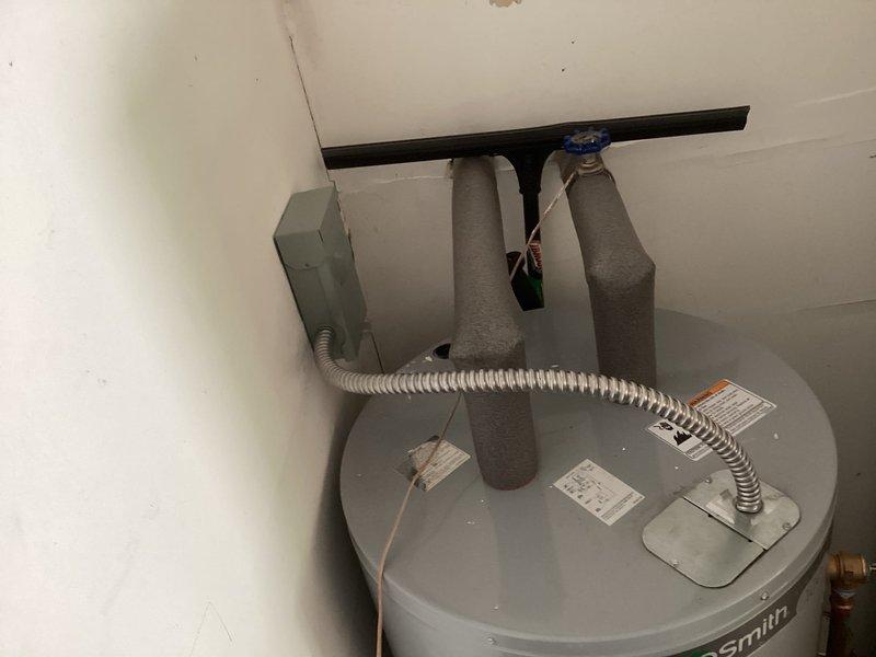 Responded to callback for recently installed A.O. Smith water heater with no hot water condition. Upon inspection, discovered the black power wire had been cut with insufficient length remaining to reconnect directly to the unit's electrical junction box. Wire will require extension to restore proper electrical connection and functionality to the water heater.