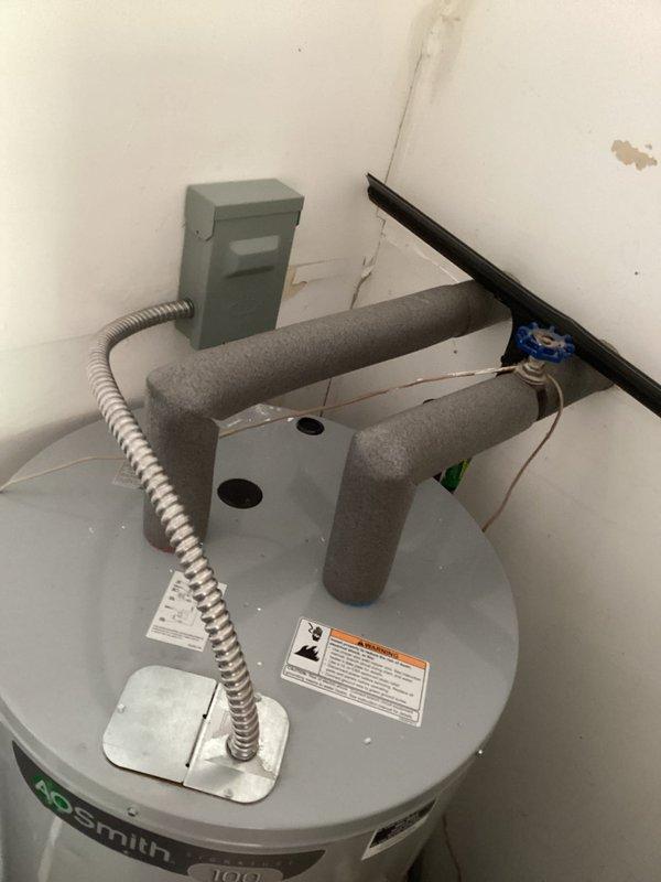 Responded to callback for recently installed A.O. Smith water heater with no hot water condition. Upon inspection, discovered the black power wire had been cut with insufficient length remaining to reconnect directly to the unit's electrical junction box. Wire will require extension to restore proper electrical connection and functionality to the water heater.