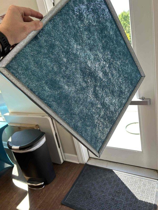 Performed preventive maintenance filter cleaning service on HVAC system with washable filters installed in the units. Removed and inspected reusable air filters which showed heavy accumulation of dust, debris, and particulate matter across the filter media surfaces. The filters displayed significant gray-white coating and uneven dust buildup that was restricting proper airflow. Documented pre-cleaning condition of filters through photographs showing the extent of contamination on the teal-colored filter media and metal frame assemblies. Completed cleaning procedure on washable filters per manufacturer specifications and returned filters to their respective unit housings. System equipped with permanent washable filters that remain installed in the units for ongoing use.