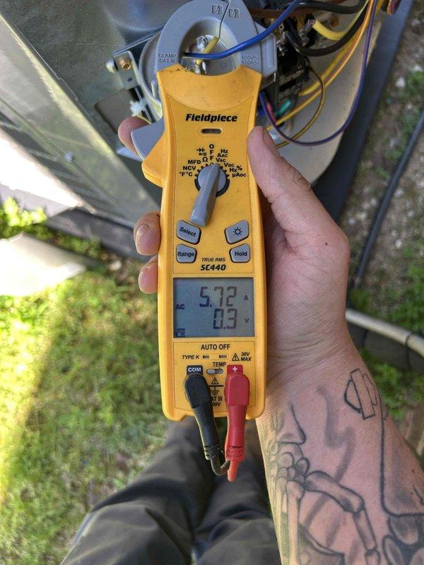 Completed club single maintenance on a 2-year-old system with indoor unit located in attic. Performed standard diagnostic measurements including temperature and electrical readings using digital meters, verified system amperage at 5.72A, and conducted visual inspection of capacitor and electrical connections. All components found operating within normal parameters during basic hands-off maintenance service.