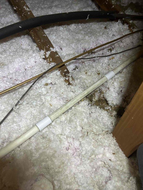 Responded to service call for water leak from AC system into bedroom. Upon arrival, inspected attic space and located clogged condensate drain line causing overflow. Cleared blockage from drain line using appropriate methods and verified proper drainage flow. Inspected surrounding insulation and structural components for water damage. Noted moisture evidence on wooden beam near drain pan area. Confirmed AC system operational with condensate draining properly through cleared line. System tested and no active leaking observed at time of departure.