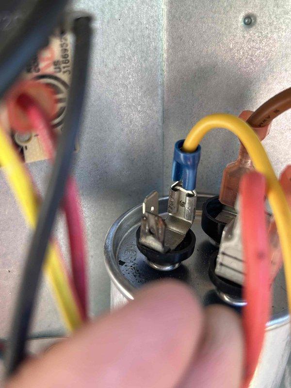 Responded to no cooling complaint on electric HVAC system with indoor unit located in attic. Upon arrival, found unit blowing air but not cooling, condition present since end of previous week. Performed diagnostic evaluation of system components and electrical connections. Inspected capacitor and associated wiring connections at contactor assembly. Used digital multimeter to test electrical components and verify proper voltage and continuity. Identified failed capacitor as root cause of cooling failure. Replaced defective dual run capacitor with proper rated replacement. Verified all wire connections secure at terminals. Tested system operation and confirmed compressor engagement and proper cooling cycle restored. Unit operating within normal parameters at time of departure.