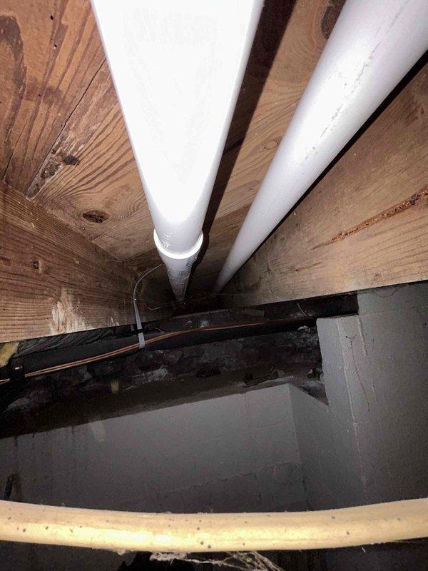 Rerouted sump pump discharge line through the front of the home with outlet to street, requiring penetration through exterior wall. Installed bucket pump system for washing machine drainage with dedicated vent line through second wall penetration. Secured all PVC discharge piping and connections in crawl space with proper mounting hardware, installed valve assembly on vertical discharge line, and verified complete system operation with no leaks detected at any connection points.