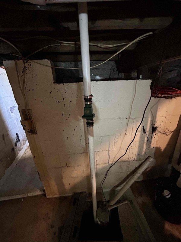 Rerouted sump pump discharge line through the front of the home with outlet to street, requiring penetration through exterior wall. Installed bucket pump system for washing machine drainage with dedicated vent line through second wall penetration. Secured all PVC discharge piping and connections in crawl space with proper mounting hardware, installed valve assembly on vertical discharge line, and verified complete system operation with no leaks detected at any connection points.