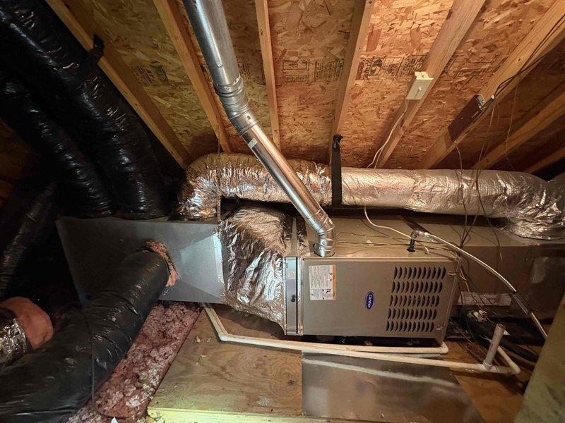 Completed installation of Carrier Comfort Series 80% AFUE 90,000 BTU gas furnace model 58SB0B090M21-16 in attic space. Installed two Honeywell TH2110WF4008/U WiFi smart thermostats for multi-zone control. Work included transition connection to existing evaporator coil, standard-sized air filter rack installation, connection to flue piping system, electrical disconnect switch, gas shut-off valve, flexible gas line connector, and flame roll-out safety protection. All ductwork connections secured to furnace plenum with proper sealing. Verified proper combustion air supply and venting configuration per manufacturer specifications. Installed PVC condensate drain line with trap and routed to approved drainage location. Completed all electrical wiring to code including 120V power supply and thermostat low-voltage wiring. Tested gas pressure at manifold and adjusted for optimal burner performance. Conducted system startup procedures including ignition sequence verification, blower motor operat