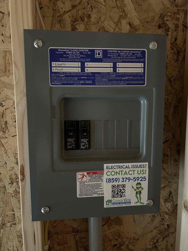 Installed complete electrical service for shop building including 100-amp Homeline load center with two circuit breakers. Wiring installation included one GFCI receptacle, two duplex receptacles, one single-pole switch, and two keyless light fixtures with bulbs. Replaced existing 2-pole 60-amp Siemens breaker dedicated to air compressor circuit. Applied service contact identification label to panel cover as requested.