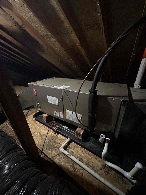 Responded to no-cool complaint on 5-year-old heat pump system located in attic. Customer reported upstairs unit not maintaining set temperature, running 2-5 degrees warmer than thermostat setting with reduced cooling capacity. Upon arrival, performed visual inspection of air handler and associated components. Examined gas valve assembly and refrigerant connections, noting moisture accumulation on interior metal surfaces indicating normal condensation. Inspected air handler unit, ductwork connections, and condensate drain lines. Observed unknown filter maintenance history which likely contributed to reduced airflow and diminished cooling performance. Documented equipment condition through photographic records showing interior mechanical components and overall system installation in attic space. System operational at time of inspection but exhibiting reduced cooling efficiency consistent with restricted airflow from neglected filter maintenance.