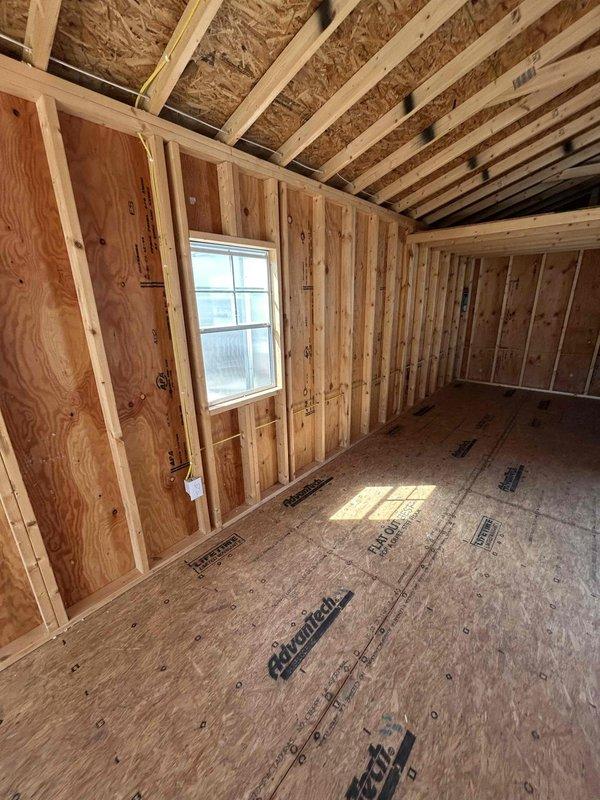 Completed electrical rough-in installation for new construction outbuilding. Installed 100-amp main panel (Peavler 14x321) with replacement 2-pole 60-amp Siemens breaker. Wired and installed circuit devices including one GFCI receptacle, two duplex receptacles, one single-pole switch, and two keyless light fixtures with bulbs. All wiring completed to code specifications within exposed stud framing prior to insulation and drywall installation.