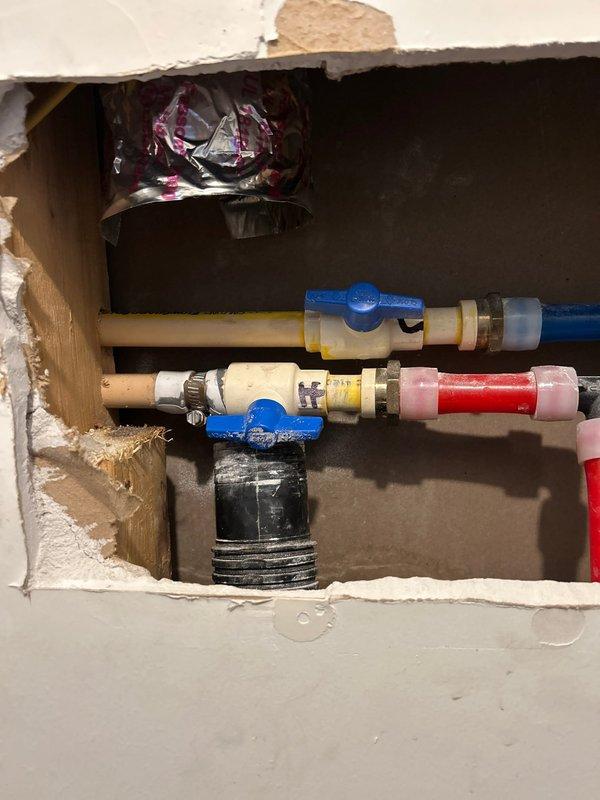 Responded to a water leak in a closet where a PVC hot water supply line was dripping. Accessed the plumbing through an existing access panel and opened the wall cavity to expose the affected area. Identified the leak source in the hot water supply line and repaired the connection using appropriate fittings. Installed blue-handled ball valves on multiple supply lines for improved shutoff capability. Replaced damaged PVC sections with PEX tubing in the configuration, securing all connections with proper fittings and connectors. Tested all repaired connections for leaks and verified proper water flow throughout the system.