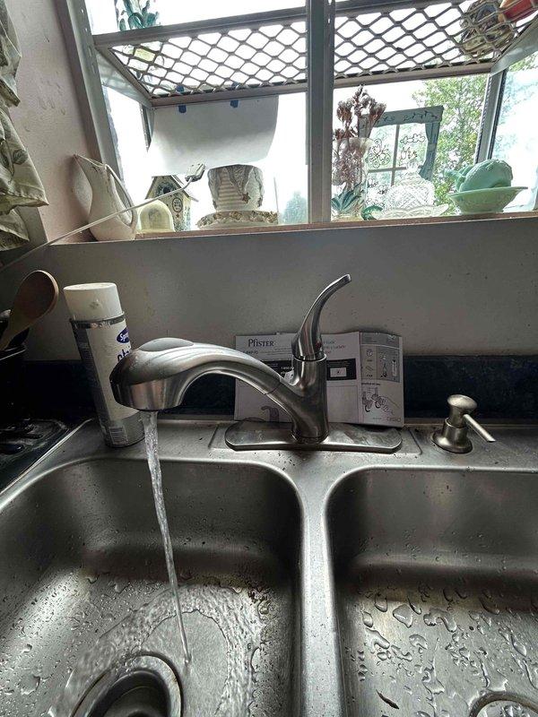 Completed installation of customer-supplied kitchen faucet with proper supply line connections and drain assembly. Replaced two leaking angle stops servicing separate bathroom sink fixtures to eliminate water seepage. Installed new Delta Monitor shower handle assembly to restore proper temperature and flow control. Modified bathroom cabinet by cutting access section and installing new P-trap configuration to bring drain system into code compliance, ensuring proper venting and trap seal.