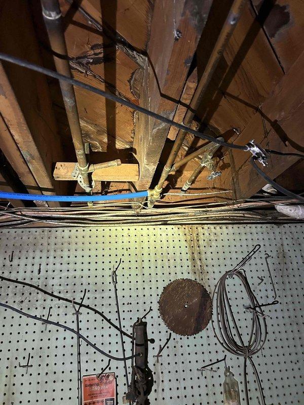 Replaced copper water line in attic space in preparation for new refrigerator installation. Routed new supply line through existing structural framework, securing properly to wooden joists and coordinating with existing utility runs including electrical wiring and HVAC components. Completed installation meets code requirements for refrigerator water connection.