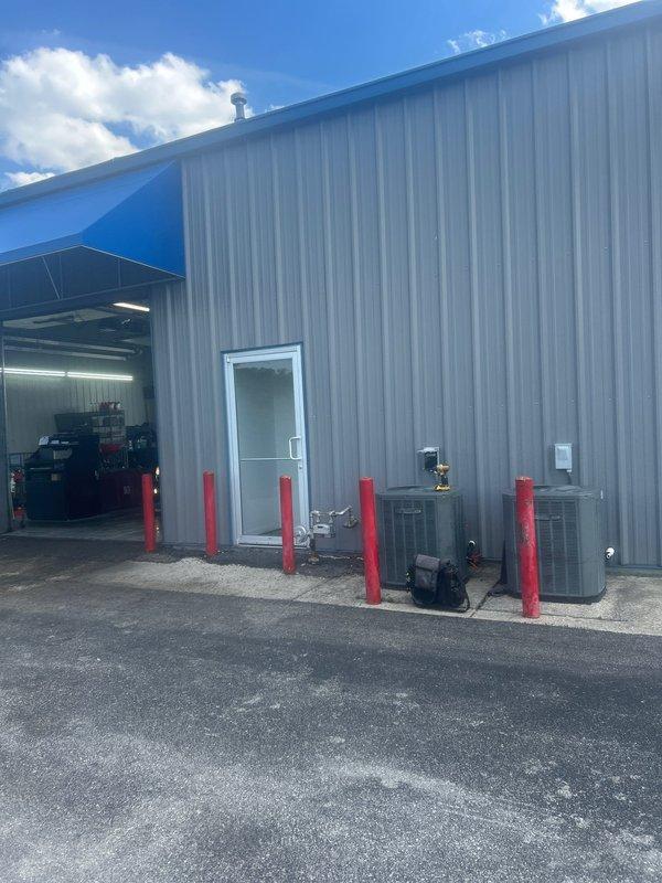 Responded to no cooling complaint at commercial facility. Upon arrival, located two commercial-grade HVAC units installed on exterior wall between protective bollards. Performed diagnostic evaluation of both units to identify cause of cooling failure and documented equipment condition with photographs for service records.