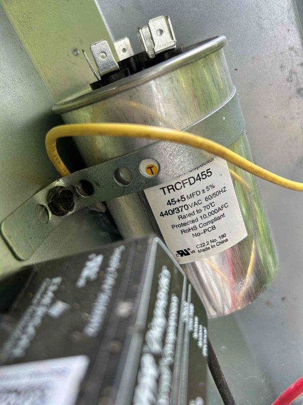Performed comprehensive air conditioning tune-up and routine maintenance on basement-located AC system. Inspected and verified proper operation of dual-run capacitor (45+5 MFD, 440/370 VAC) with all terminals securely connected, examined refrigerant sight glass showing appropriate charge levels with green indicator fluid, and documented system conditions through photographic records. Noted 20x25x4 filter size for replacement during scheduled fall visit.