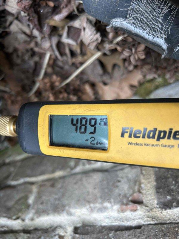 Performed evaporator coil replacement on residential HVAC system. Accessed unit with assistance from neighbor as arranged. Removed failed evaporator coil and installed new replacement unit. Evacuated system using vacuum pump to proper micron levels, verified with wireless vacuum gauge showing acceptable readings. Recharged system with 17 pounds of R410A refrigerant to manufacturer specifications. Inspected capacitor, copper line connections, and condenser coil during service. Tested system operation and confirmed proper cooling performance upon completion. Total service time was 5 hours.