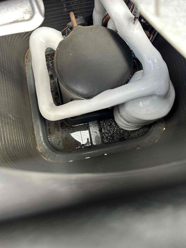 Responded to no cooling call on electric HVAC system with air handler located in attic. Upon inspection, found standing water in condensate drain pan with visible debris accumulation, indicating potential drain line blockage affecting system operation. Documented attic-mounted air handler unit and flexible ductwork installation, noting insulation condition and PVC condensate drain configuration with proper trap assembly. Photographed equipment nameplate for age verification and captured drain pan condition showing sediment buildup in standing water. System evaluated for repair versus replacement recommendation given age of equipment exceeding ten years.