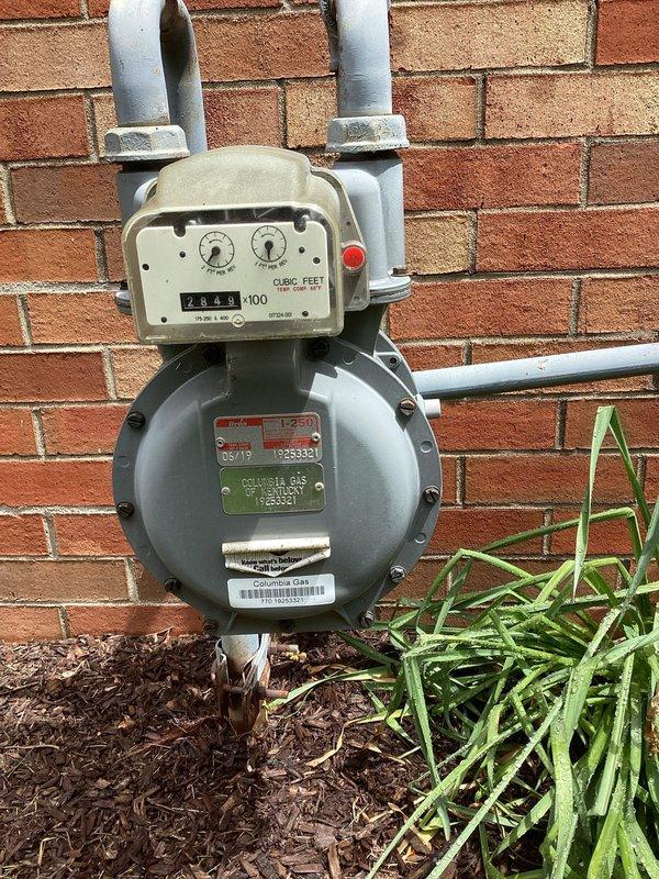 Completed electrical estimate for residential backup generator installation. Assessed existing natural gas meter infrastructure and utility connection point on exterior brick wall, confirming adequate gas supply capacity for generator integration. Evaluated interior electrical panel location in bathroom/laundry area for transfer switch installation and load center modifications required to support automatic standby generator system.
