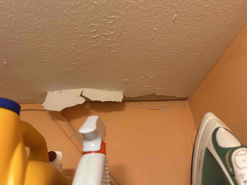 Responded to callback for ongoing system leak. Upon arrival, performed visual inspection of affected area where previous leak was reported. Documented existing water damage to interior wall and ceiling junction, showing paint deterioration and substrate exposure. Examined HVAC system components in vicinity of damage. Located evidence of moisture infiltration at drain line connection point, with visible mineral deposits and crystallization present at pipe junction. Identified compromised drain line seal as source of continued leakage. Captured photographic documentation of damaged areas and leak source for service records.