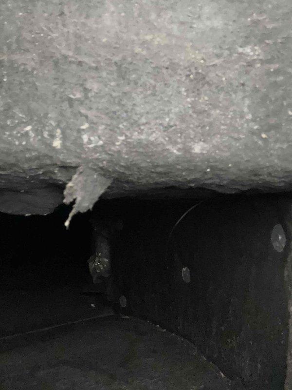 Responded to callback for ongoing system leak. Upon arrival, performed visual inspection of affected area where previous leak was reported. Documented existing water damage to interior wall and ceiling junction, showing paint deterioration and substrate exposure. Examined HVAC system components in vicinity of damage. Located evidence of moisture infiltration at drain line connection point, with visible mineral deposits and crystallization present at pipe junction. Identified compromised drain line seal as source of continued leakage. Captured photographic documentation of damaged areas and leak source for service records.