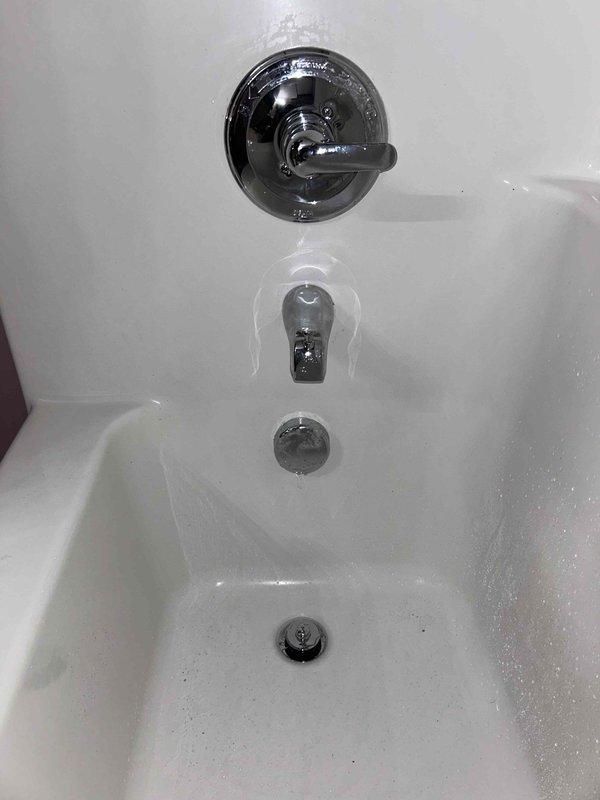 Replaced existing shower valve with customer-supplied Delta valve and trim, requiring access panel creation by cutting drywall behind shower wall to reach plumbing assembly. Installed new waste and overflow assembly for bathtub drainage system. Connected valve to existing copper supply lines, secured mounting plate, and installed chrome trim components including single-handle diverter valve and tub spout. Verified proper water flow, temperature control, and drainage functionality upon completion, then removed old parts and debris from work area.