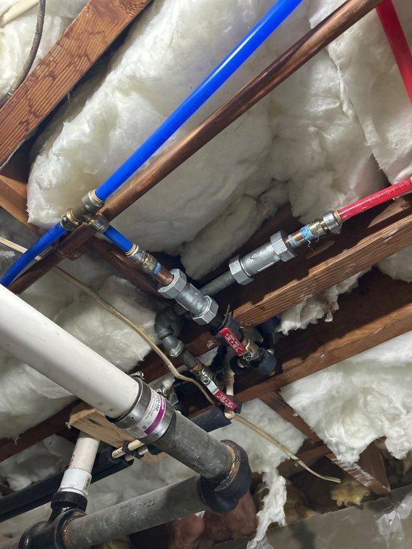 Completed comprehensive 60-point visual whole home plumbing inspection without water heater flush. Serviced Rheem 80-gallon heat pump hybrid water heater by removing, cleaning, and reinstalling the air intake filter located at the top of the unit per maintenance alert reminder. Filter was rinsed with water, allowed to dry completely, and reinstalled to ensure optimal heat pump performance. Documented existing plumbing infrastructure including copper supply lines, PEX hot and cold water distribution lines, PVC drainage, compression fittings, and ball valves throughout accessible areas.