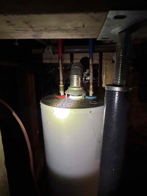 Responded to no hot water complaint at residential property. Upon inspection, diagnosed tanked water heater in basement with complete loss of hot water production. Assessed unit condition, verified electrical connections and plumbing infrastructure, and documented equipment setup including pressure relief valve, supply lines with color-coded insulation, and ventilation system. Photographed water heater installation and surrounding mechanical components for service records. Customer advised of findings and recommendations for restoration of hot water service.