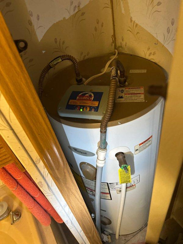 Completed routine plumbing inspection of residential property. Examined bathtub drain assembly, noting mineral buildup and rust-colored staining around drain rim consistent with normal aging and hard water deposits. Inspected water heater installation in utility closet, verifying proper positioning, venting configuration with flexible metal conduits, and confirming all manufacturer labels and safety warnings remain visible and intact.