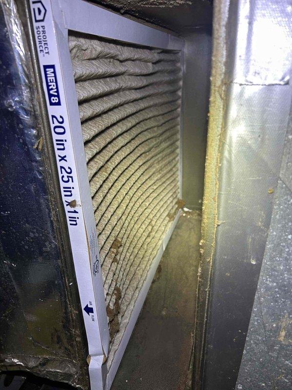 Responded to no cooling complaint with system freezing at refrigerant lines. Upon arrival, found air handler operating but producing inadequate cooling with ice formation on suction line. Inspected indoor unit and discovered heavily soiled MERV 8 filter (20x25x1) with significant dust accumulation and debris buildup restricting airflow. Restricted airflow identified as primary cause of evaporator coil freeze-up condition. Recommended immediate filter replacement and system monitoring after thaw cycle to restore proper cooling operation.