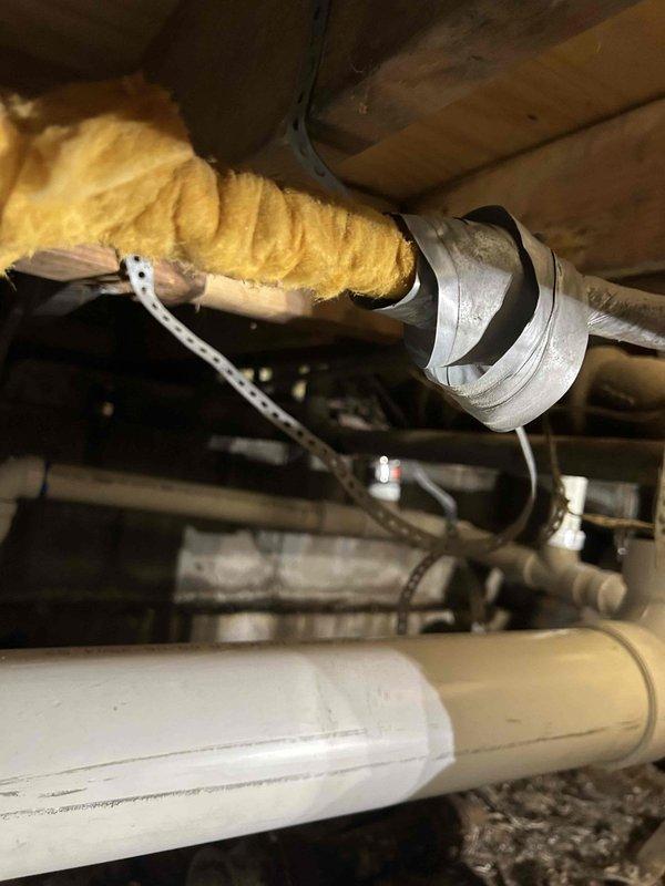 Completed drain line repipe in crawlspace to correct improper installation from previous contractor. Removed deteriorated and corroded metal drain piping that showed advanced rust and structural failure. Installed new white PVC drain piping with proper slope, support, and code-compliant fittings throughout the affected section. Secured all new piping to floor joists using metal strapping at appropriate intervals to ensure stability and prevent sagging. Tested the drainage system upon completion to verify proper flow and confirm all connections are leak-free and functioning reliably.