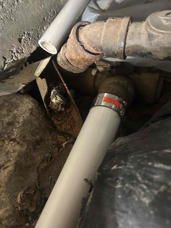 Completed drain line repipe in crawlspace to correct improper installation from previous contractor. Removed deteriorated and corroded metal drain piping that showed advanced rust and structural failure. Installed new white PVC drain piping with proper slope, support, and code-compliant fittings throughout the affected section. Secured all new piping to floor joists using metal strapping at appropriate intervals to ensure stability and prevent sagging. Tested the drainage system upon completion to verify proper flow and confirm all connections are leak-free and functioning reliably.
