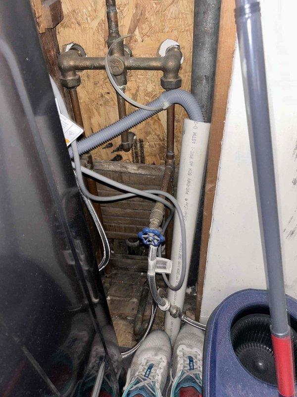 Responded to service call for clogged bathtub drain on main floor. Upon inspection, accessed plumbing infrastructure behind wall cavity and beneath structure to diagnose drainage issue. Found heavily corroded drain assembly and trap components with significant rust and oxidation buildup restricting water flow. Removed wall access panel to examine water supply lines, shut-off valves, and drainage piping. Identified deteriorated metal drain fixture as primary cause of blockage. Cleared obstruction and assessed condition of connecting PVC drainage lines and galvanized piping. Documented existing plumbing configuration including brass fixtures, PEX supply lines, and drain assembly for maintenance records. Restored proper drainage function to bathtub.